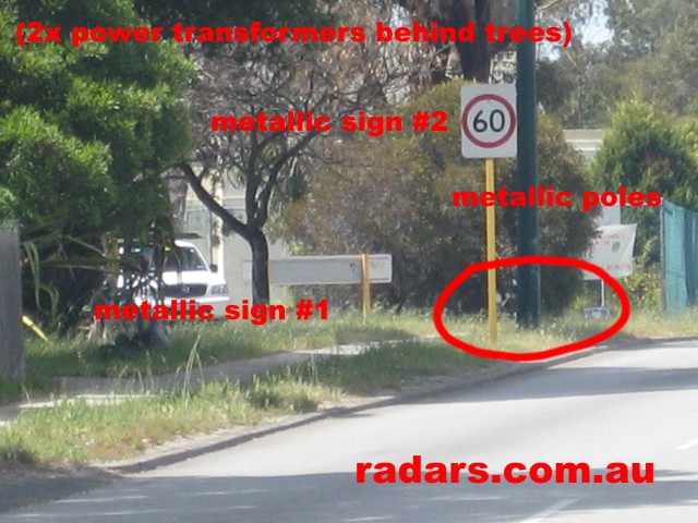 Metallic signs in front of a Multanova speed camera.