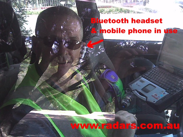 Police speed camera operator on a mobile phone.